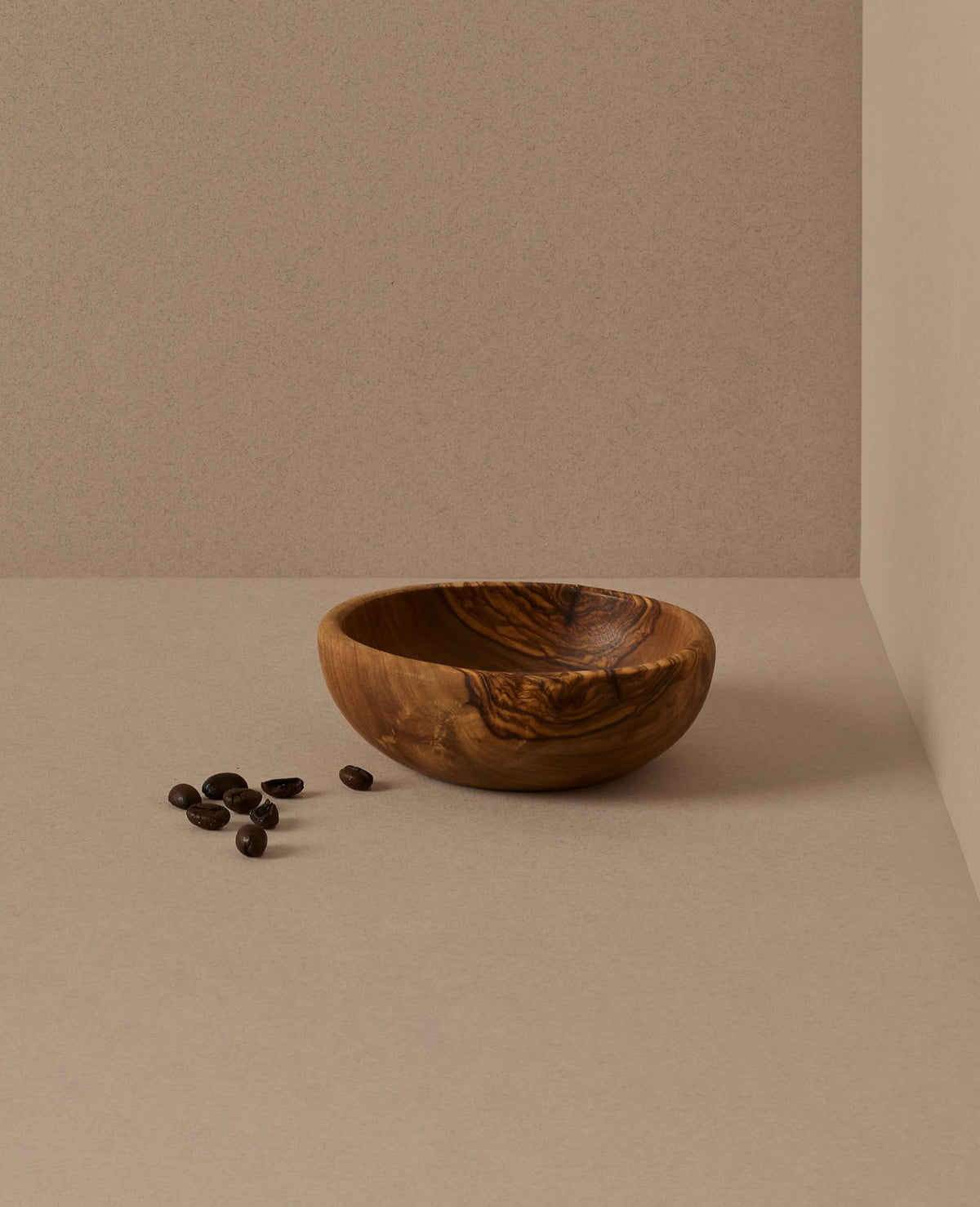 A set of natural olive wood bowls in various sizes, with the smallest bowls containing lemons. The bowls display a beautiful wood grain pattern.