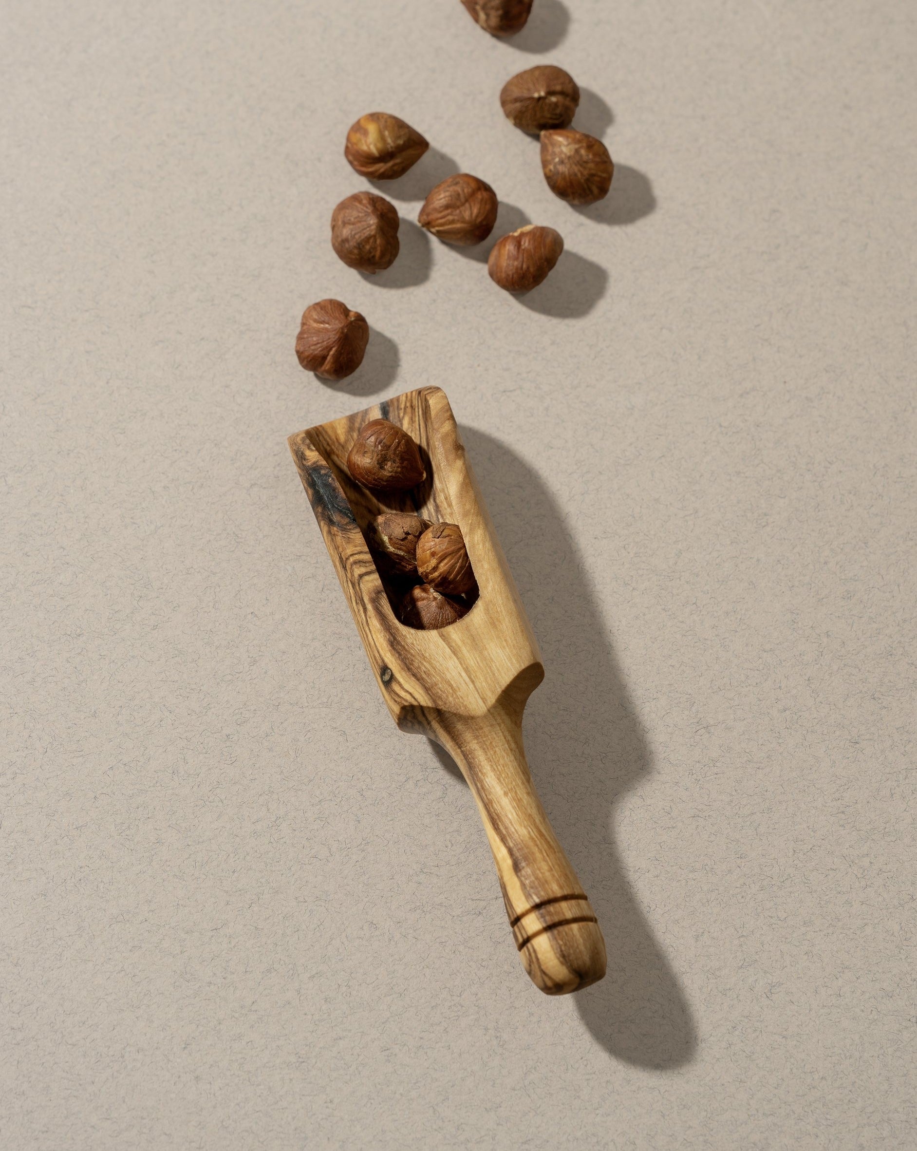 A collection of wooden scoops of various sizes, displayed against a neutral background.