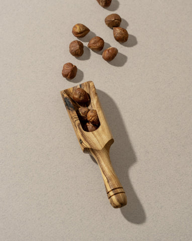 A collection of wooden scoops of various sizes, displayed against a neutral background.