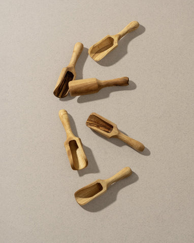 A collection of wooden scoops of various sizes, displayed against a neutral background.